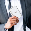 a guy in a suit holding a flask monogrammed with JMD