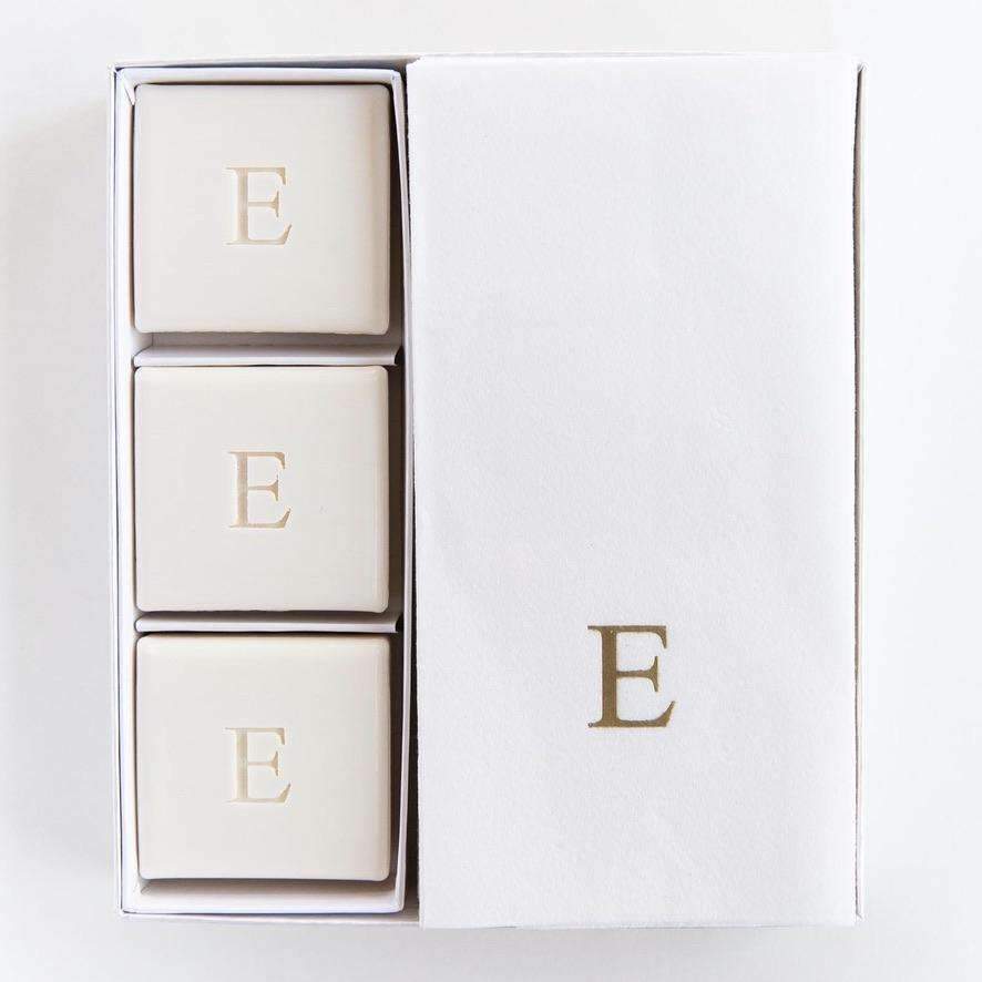 set of three square soaps monogrammed with E and towel next to it also monogrammed with E